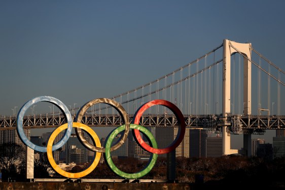 Olympic rings are seen at sunrise in front of Tokyo's iconic Rainbow Bridge and Tokyo Tower at Odaiba Marine Park