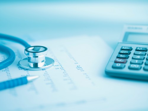 Close up of calculator, data and stethoscope