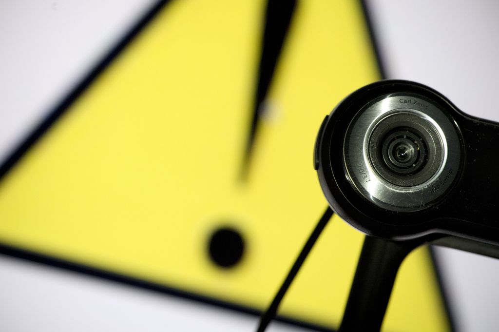 A webcam is positioned in front of a danger sign