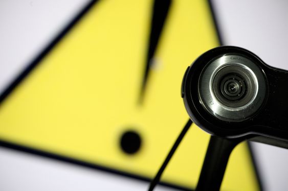 A webcam is positioned in front of a danger sign