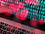 Fibre optic data containing a computer virus hitting a laptop screen.