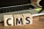 wooden blocks spell out C-M-S.