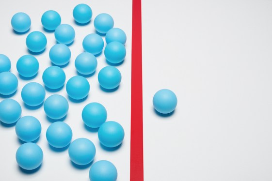 One blue ball on one right side of red line, many blue balls on left side