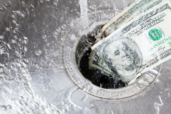 Image of two hundred dollar bills being rinsed down a drain.
