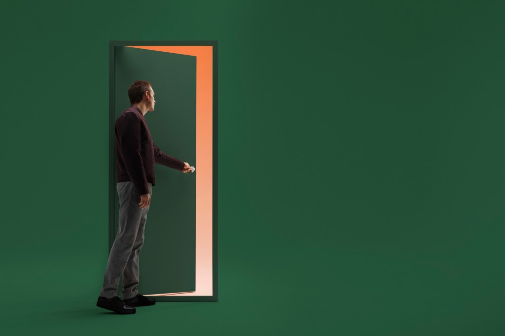 Man opening door in futuristic room