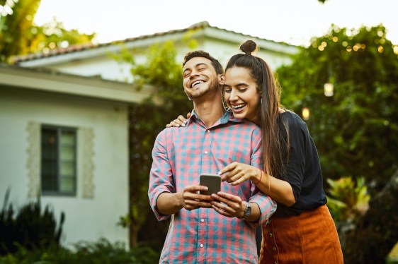 Cheerful couple looking at smart phone. Young man and woman are wearing casuals. They are having fun in back yard (Cheerful couple looking at smart phone. Young man and woman are wearing casuals. They are having fun in back yard, ASCII, 114 components