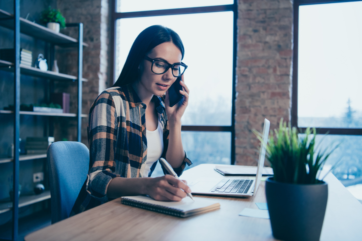 Portrait of her she nice attractive charming lovely focused brunette lady in checked shirt discussing chatting client support at industrial loft style interior work place station.