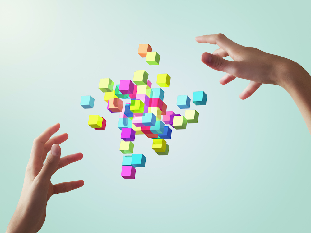 Colorful cubes forming geometric shapes with girls hands