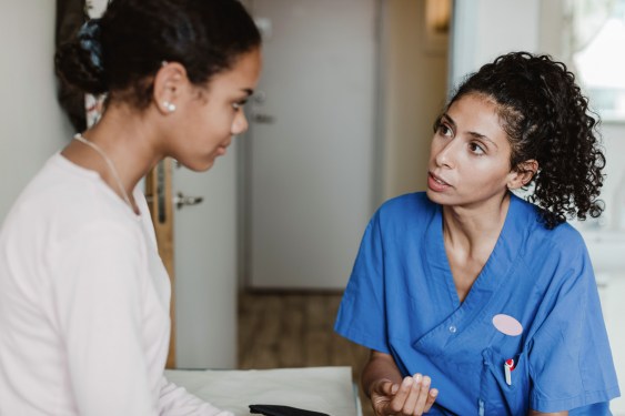 Female doctor discussing with patient in medical room at hospital