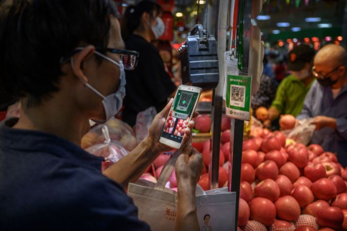 BEIJING, CHINA - SEPTEMBER 19: A Chinese customer uses his mobile to pay via a QR code with the WeChat app at a local market on September 19, 2020 in Beijing, China. (Photo by Kevin Frayer/Getty Images)