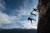 Three rock climbers helping one from falling in a dramatic setting