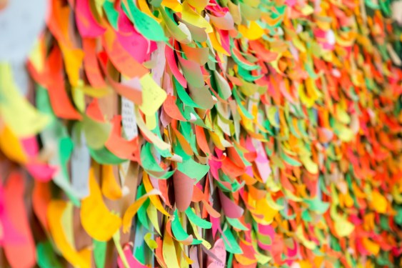 100s of colorful sticky notes on a wall.