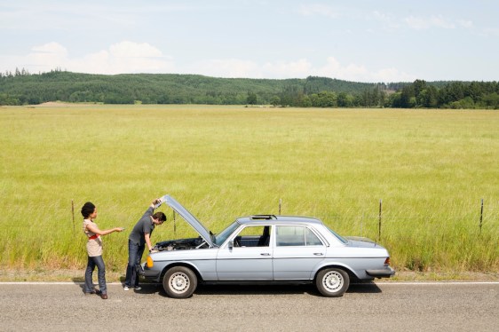 Couple looking under car hood