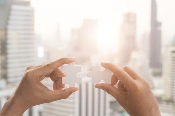Closeup hand of woman connecting jigsaw puzzle with sunlight effect