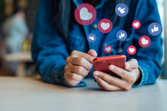Midsection Of Woman Using Smart Phone On Table In Cafe