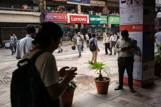 people on city street looking at their smartphones