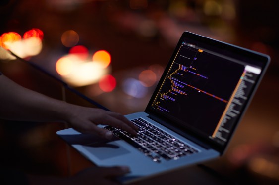 Shot of developer's hands on keyboard in darkened room