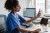 Female healthcare worker talking on video conference through mobile phone in doctor's office