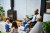 Mid adult man sitting on chair smiling at two daughters playing with blocks, modern life, fatherhood, care, family