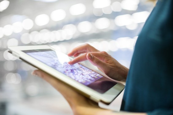 Cropped image of businesswoman using digital tablet in office
