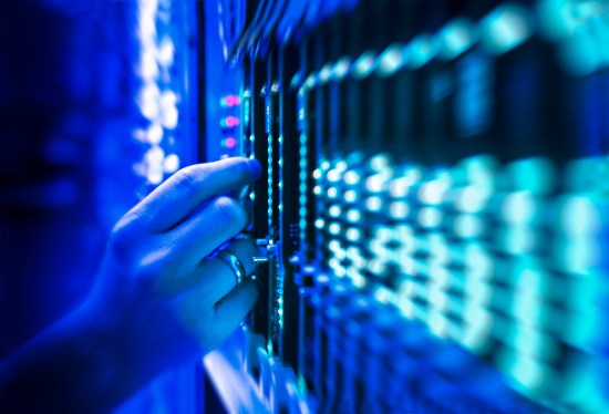 network server technician in data center bathed in blue light