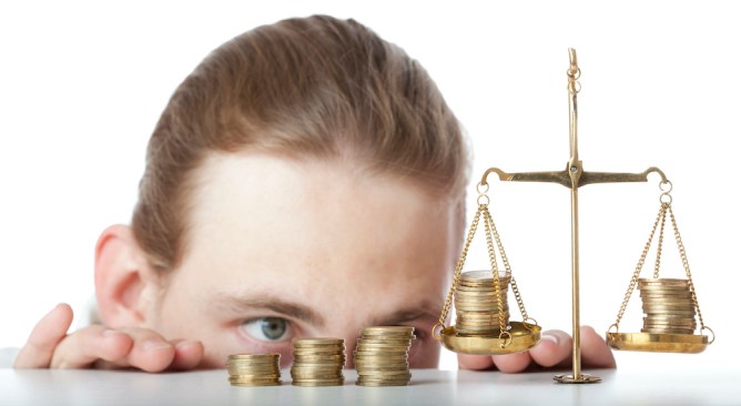Man weighing currency on scales of justice.