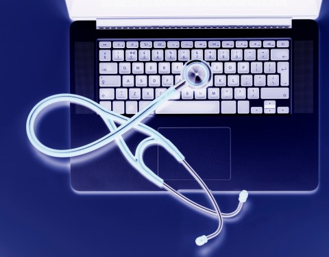 Overhead view of stethoscope on laptop