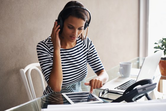 A young businesswoman wearing a headset while using a digital tablet