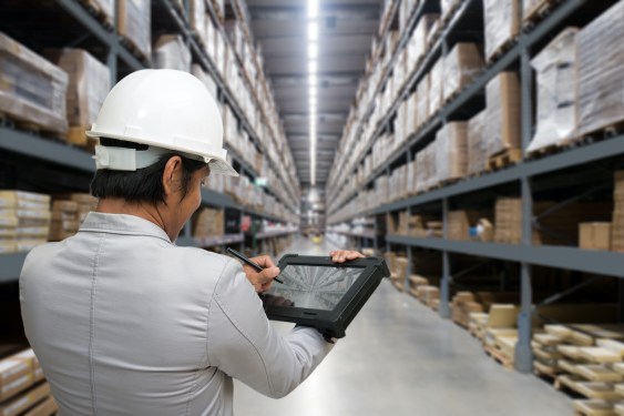 Young man looking up details on a tablet on the shops in a hardware warehouse for supplies , Business concept. (Young man looking up details on a tablet on the shops in a hardware warehouse for supplies , Business concept., ASCII, 111 components, 111