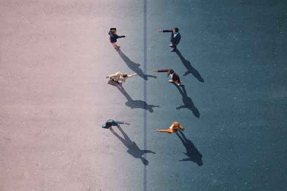 Group of young adults, photographed from above, on various painted tarmac surface, at sunrise.
