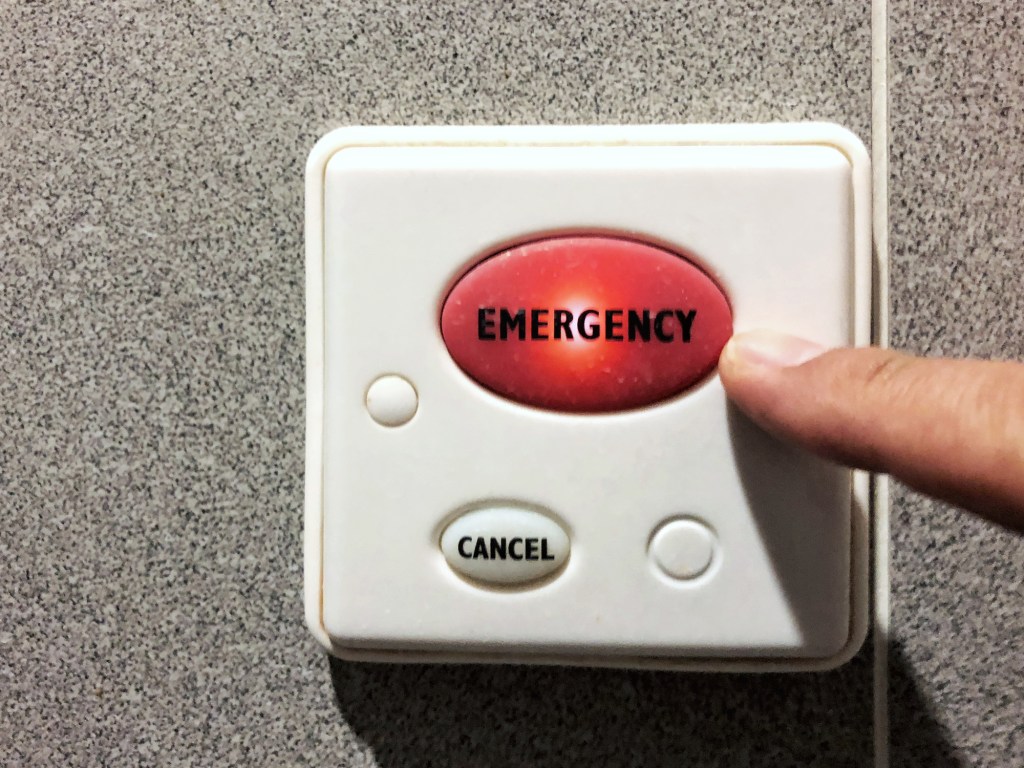 Close-up of finger indicating the big emergency red button switch