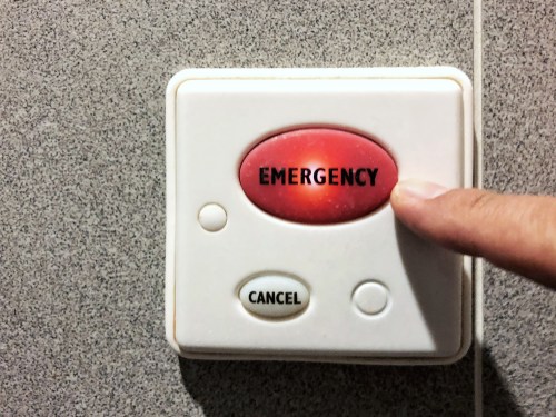 Close-up of finger indicating the big emergency red button switch