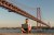 Man using laptop at 25th of April Bridge in Lisbon, Portugal