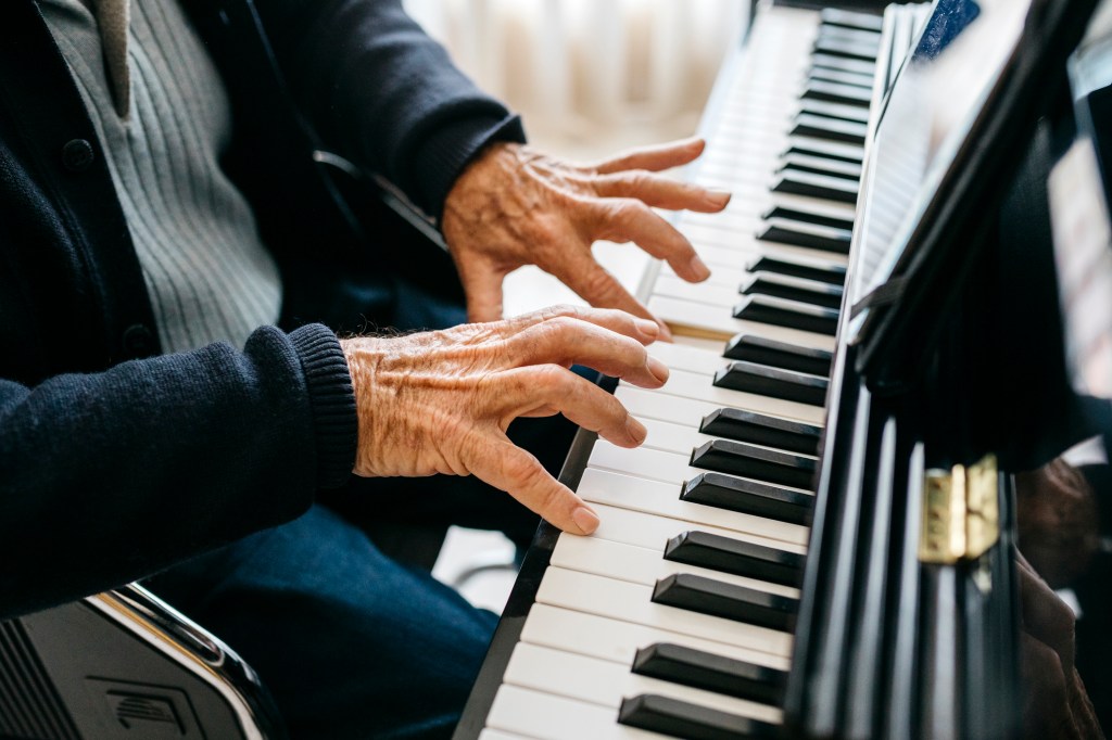 Cropped view of senior man playing piano