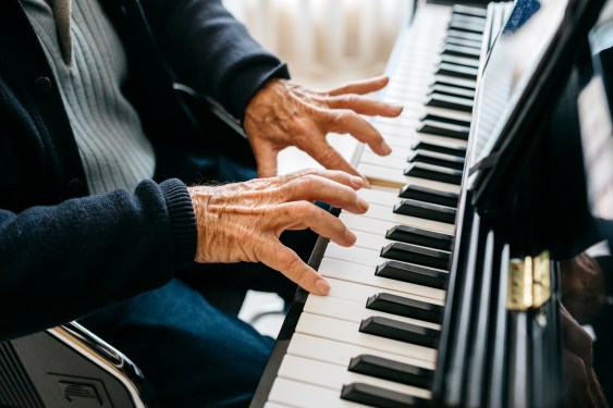 Cropped view of senior man playing piano