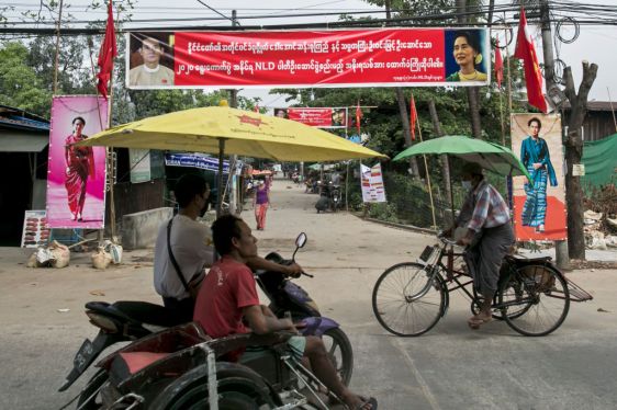 Commuters make their way in front of the banners ahead of the reopening of the parliament on February 1 following the November 2020 elections which Aung San Suu Kyi's ruling National League of Democracy (NLD) won in a landslide, in Yangon on January 30, 2021. (Photo by Sai Aung MAIN / AFP) (Photo by SAI AUNG MAIN/AFP via Getty Images)