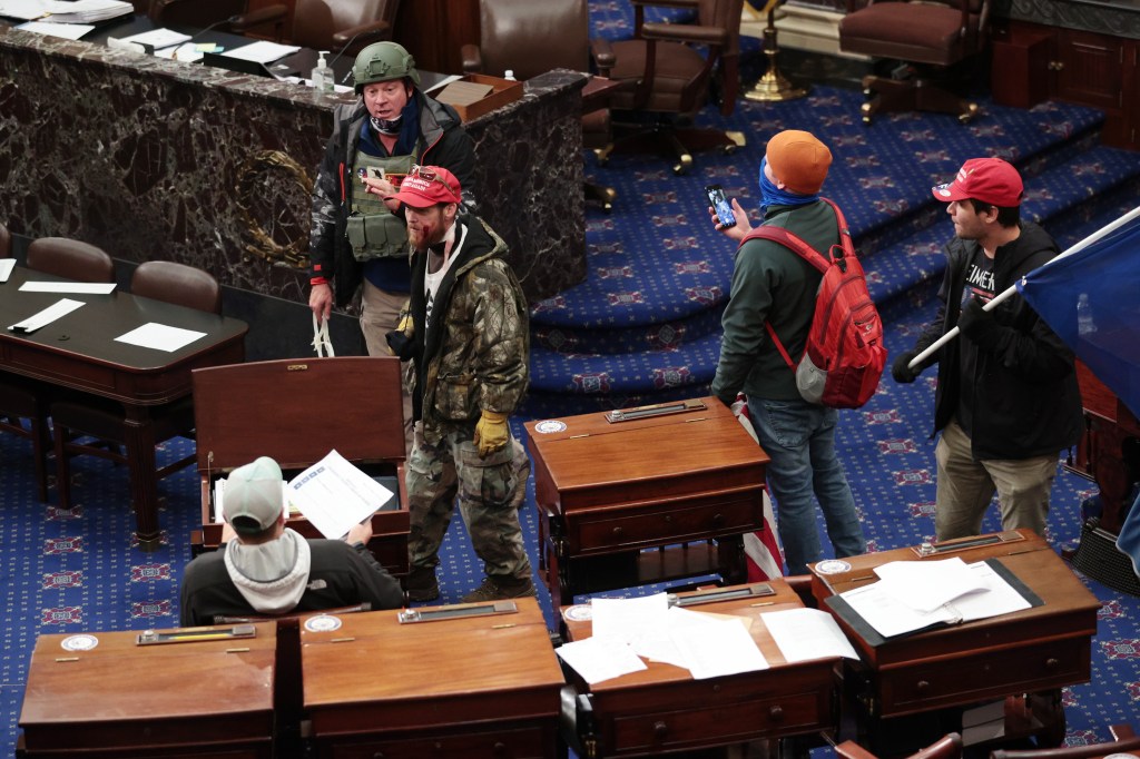 WASHINGTON, DC - JANUARY 06: Protesters enter the Senate Chamber on January 06, 2021 in Washington, DC. Congress held a joint session today to ratify President-elect Joe Biden's 306-232 Electoral College win over President Donald Trump. Pro-Trump protesters have entered the U.S. Capitol building after mass demonstrations in the nation's capital. (Photo by Win McNamee/Getty Images)
