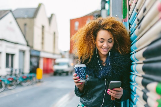 Smiling Woman Listening Music on the Mobile Phone