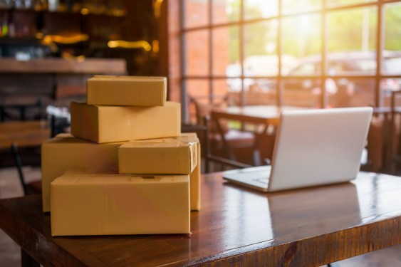 Packing accessories and cardboard boxes behind a desk with laptop