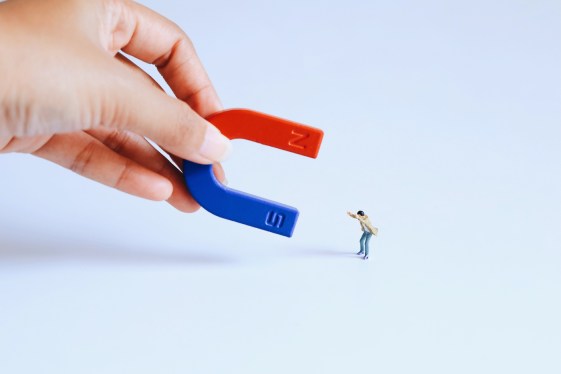 Cropped Hand Holding Magnet Toy Against White Background