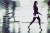 Businesswoman Walking Through The Office Corridor and Carrying Tablet