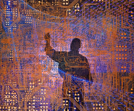 A silhouetted Information Technology professional is working within a complex network of computer circuitry and light trails.