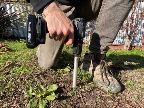 Person using Yard Stick measurement tool in soil