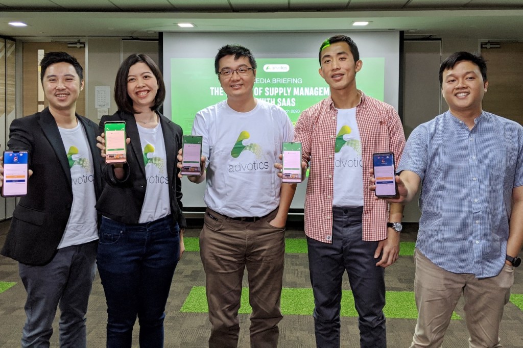 From left to right: Advotics' co-founder and CEO Boris Sanjaya, Head of Growth Venny Septiani, co-founder and CTO Hendi Chandi, co-founder and CPO Jeffry Tani, and a representative from Danone, holding smartphones displaying Advotics’ apps