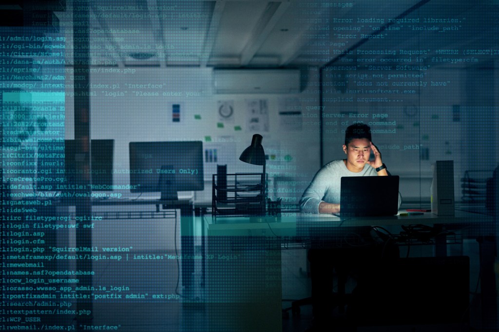 Developer coding alone in an office at night with code overlaying the picture.
