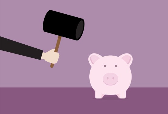 Businessman with hammer hitting a piggy bank