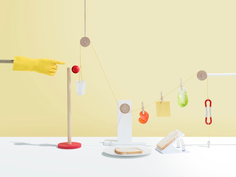 Based on the Rube Goldberg machines where simple tasks are made complicated