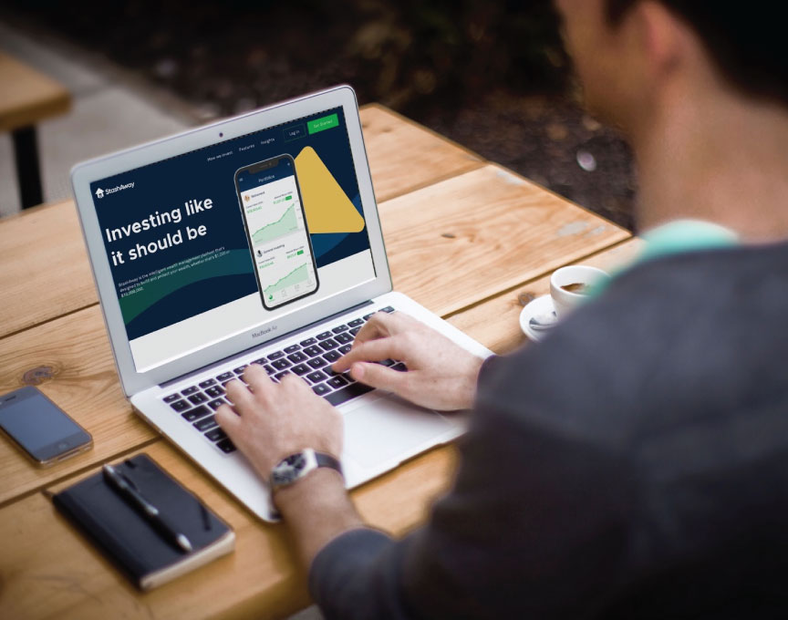 A photo of a man sitting at a laptop with a presentation from investment app StashAway