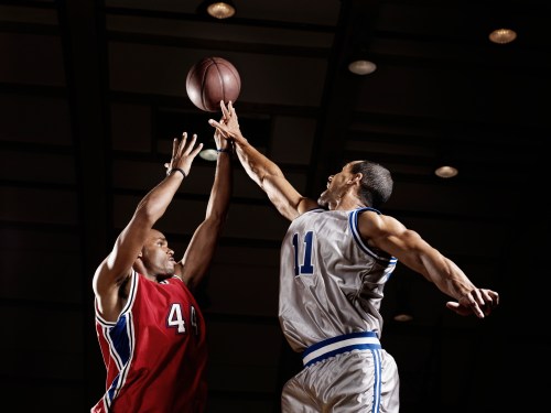 Basketball player trying to take basketball from opponent