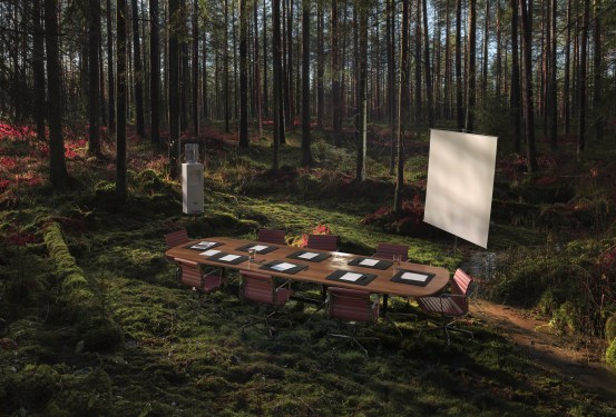 Image of an empty conference table in the middle of the forest.